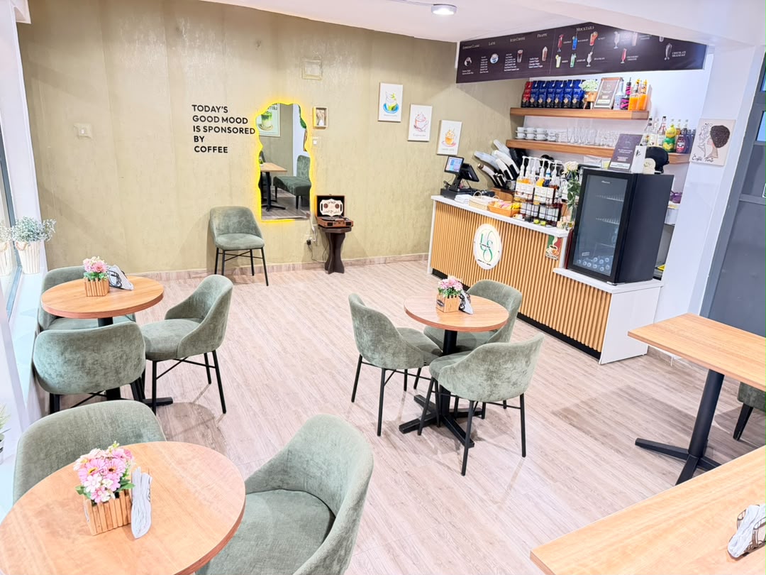 Interior of US Coffee Shop with green chairs, wooden tables and the coffee bar